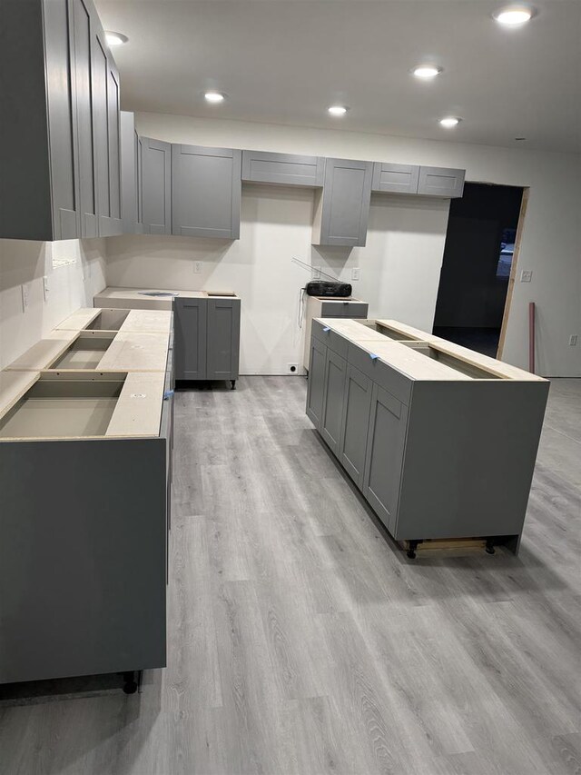 kitchen featuring gray cabinetry, a center island, and light hardwood / wood-style floors