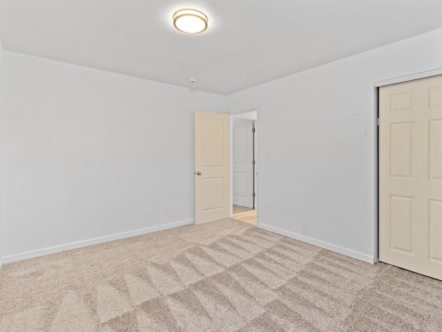 unfurnished bedroom with light carpet and a closet