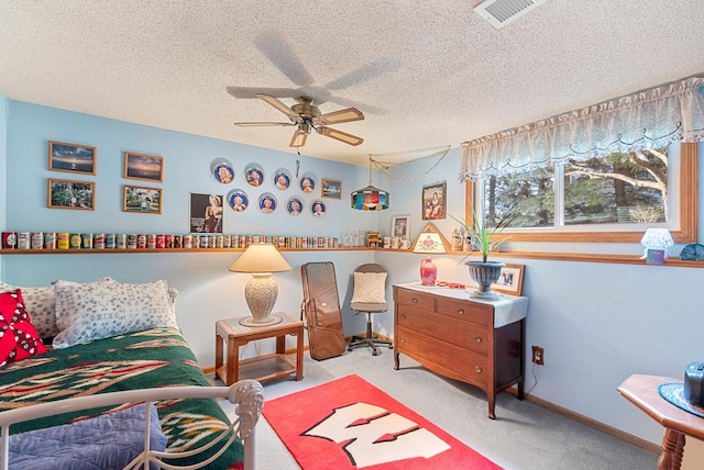 bedroom with ceiling fan, light colored carpet, and a textured ceiling