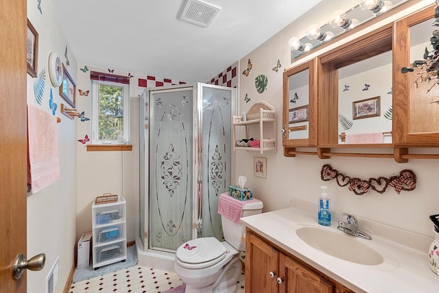 bathroom featuring vanity, toilet, and a shower with shower door