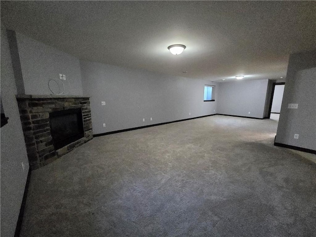 basement featuring carpet flooring, a fireplace, and a textured ceiling