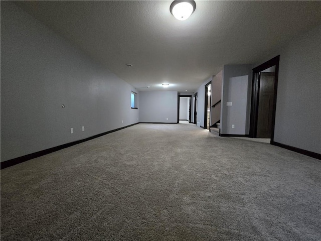 carpeted empty room featuring a textured ceiling