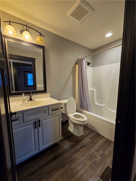 full bathroom with wood-type flooring, vanity, toilet, and shower / bath combo