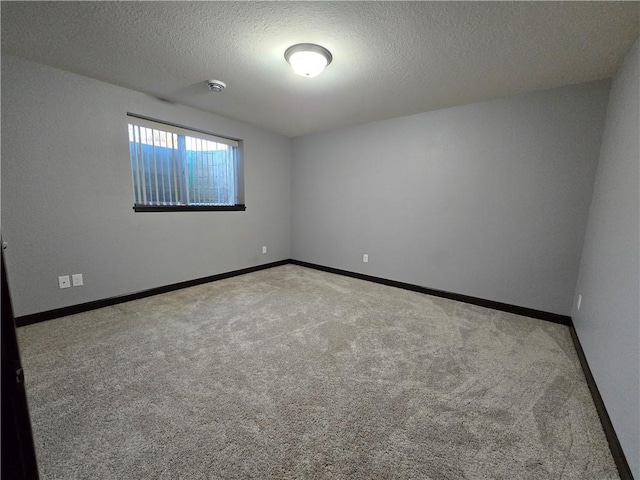 spare room with a textured ceiling and light carpet