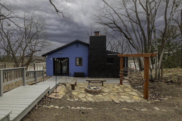 rear view of house with an outdoor fire pit