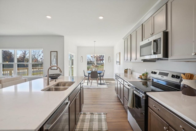 kitchen with appliances with stainless steel finishes, plenty of natural light, pendant lighting, and sink