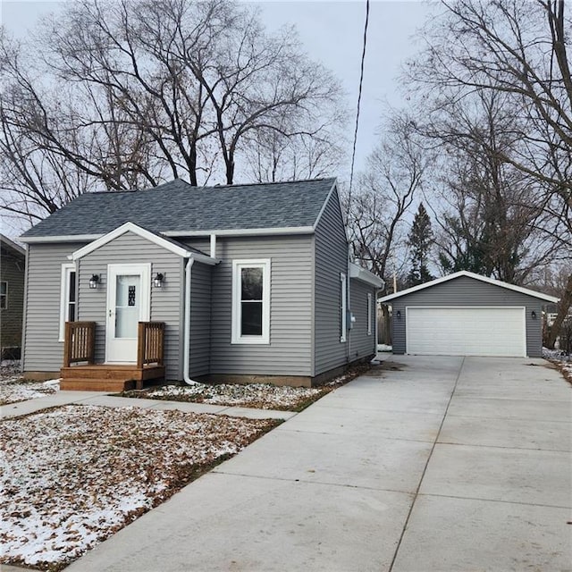 view of front of house with a garage and an outbuilding