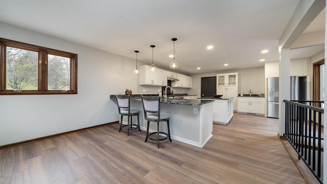 kitchen with stainless steel appliances, white cabinets, and wood-type flooring