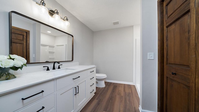 bathroom with a shower, a textured ceiling, toilet, vanity, and hardwood / wood-style flooring