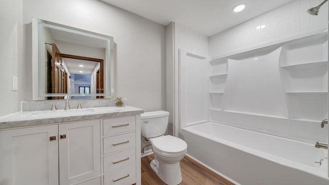 full bathroom featuring toilet, hardwood / wood-style floors, vanity, and washtub / shower combination