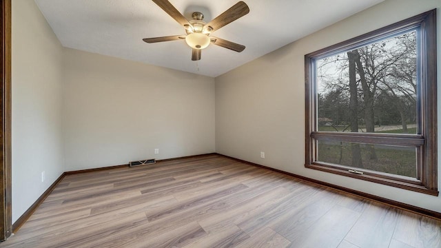 empty room with ceiling fan and light hardwood / wood-style flooring