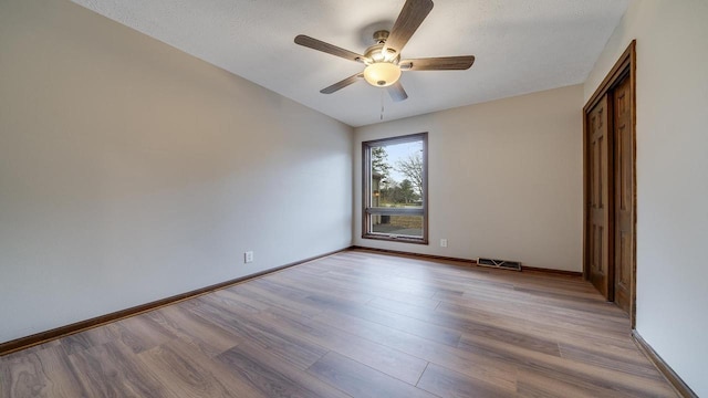 unfurnished bedroom with ceiling fan, light hardwood / wood-style floors, and a textured ceiling