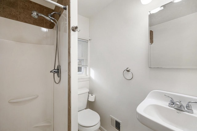 bathroom featuring walk in shower, sink, and toilet