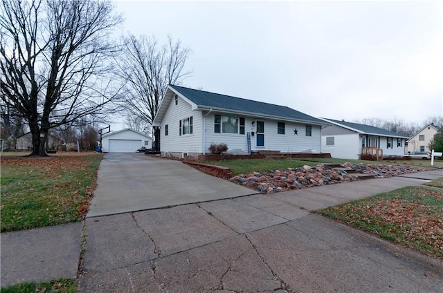 ranch-style home with a garage, an outbuilding, and a front lawn