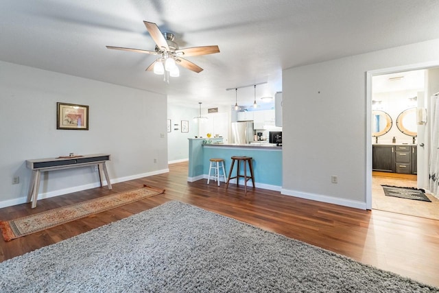 living room with ceiling fan and dark hardwood / wood-style floors