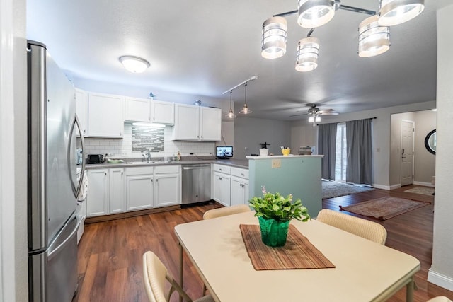 kitchen featuring white cabinets, appliances with stainless steel finishes, dark hardwood / wood-style floors, and sink