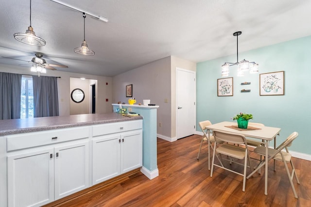 kitchen with dark hardwood / wood-style floors, ceiling fan, a textured ceiling, decorative light fixtures, and white cabinetry