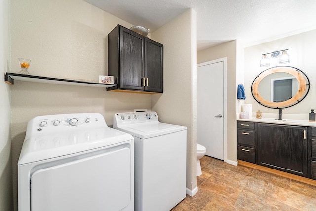 laundry area with sink, a textured ceiling, and washing machine and clothes dryer