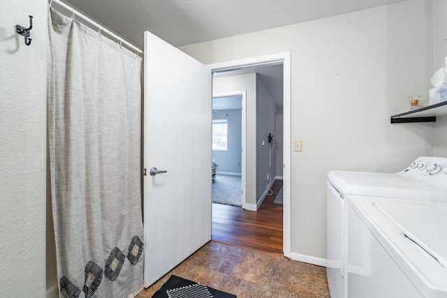 laundry room with washer and clothes dryer and dark wood-type flooring