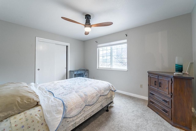 bedroom with a closet, light colored carpet, and ceiling fan