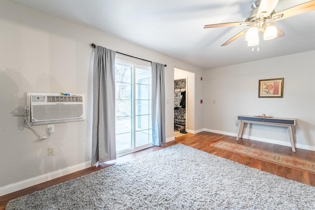 interior space featuring hardwood / wood-style flooring, an AC wall unit, and ceiling fan