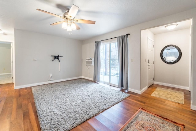 entrance foyer featuring an AC wall unit, ceiling fan, and dark hardwood / wood-style flooring