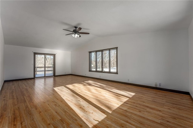 empty room with ceiling fan, vaulted ceiling, and hardwood / wood-style flooring