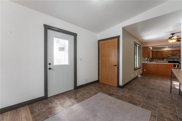 foyer featuring ceiling fan, sink, and lofted ceiling