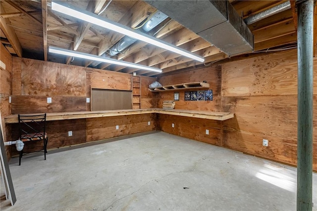 basement featuring a workshop area and wood walls