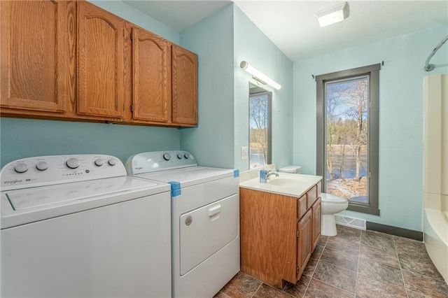 clothes washing area with washing machine and dryer and sink