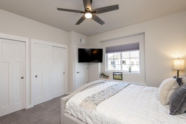 bedroom featuring carpet, two closets, and ceiling fan