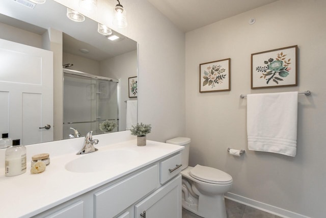 bathroom featuring vanity, toilet, and a shower with door