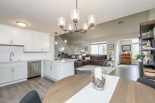 dining area with sink, light hardwood / wood-style floors, and an inviting chandelier