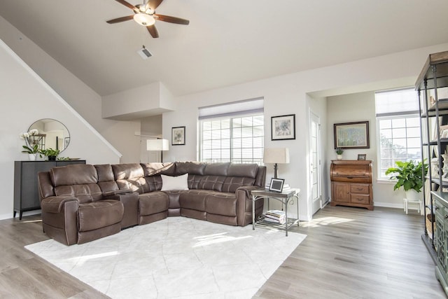 living room with ceiling fan, light hardwood / wood-style floors, and lofted ceiling