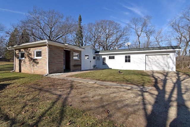 back of property featuring a garage and a lawn