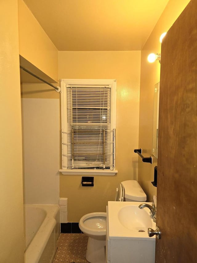 bathroom with tile patterned flooring, vanity, toilet, and a tub