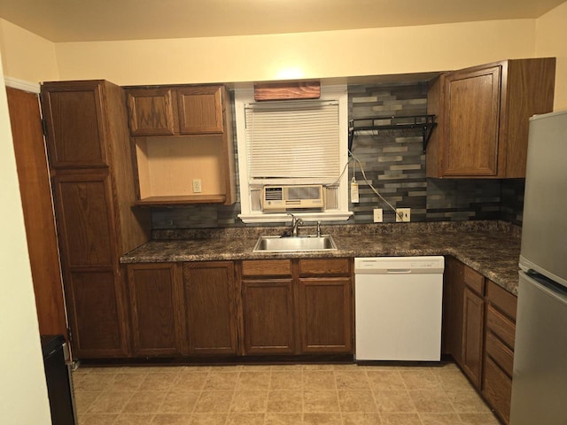 kitchen featuring white appliances, backsplash, cooling unit, sink, and dark stone countertops