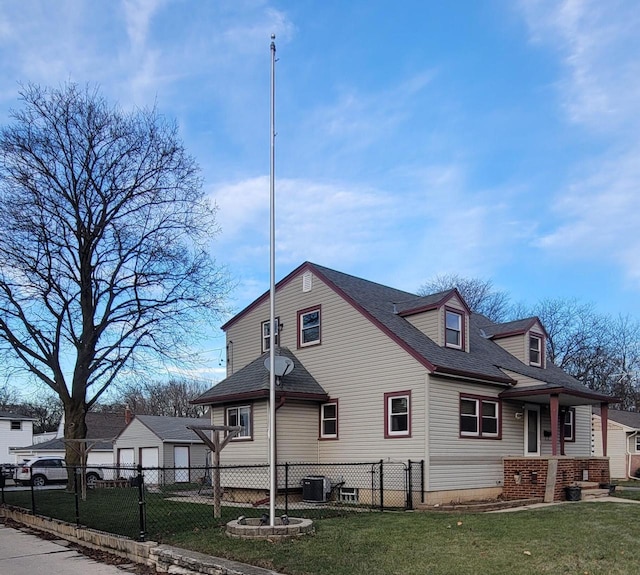 view of side of property featuring central air condition unit and a lawn