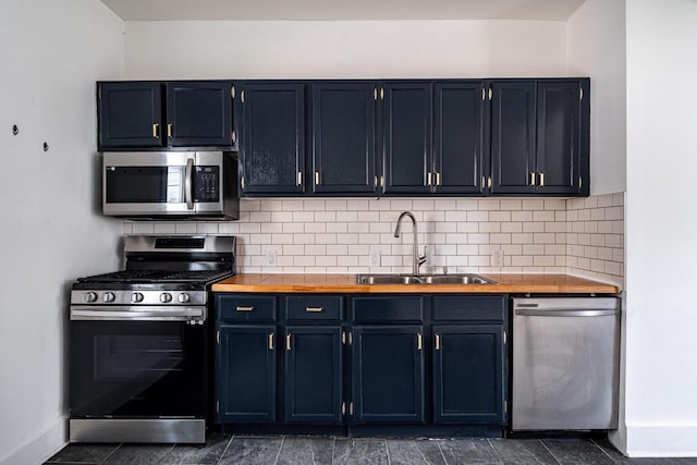 kitchen featuring blue cabinetry, sink, stainless steel appliances, and tasteful backsplash