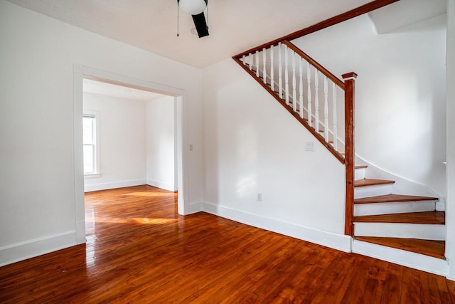 staircase featuring wood-type flooring and ceiling fan