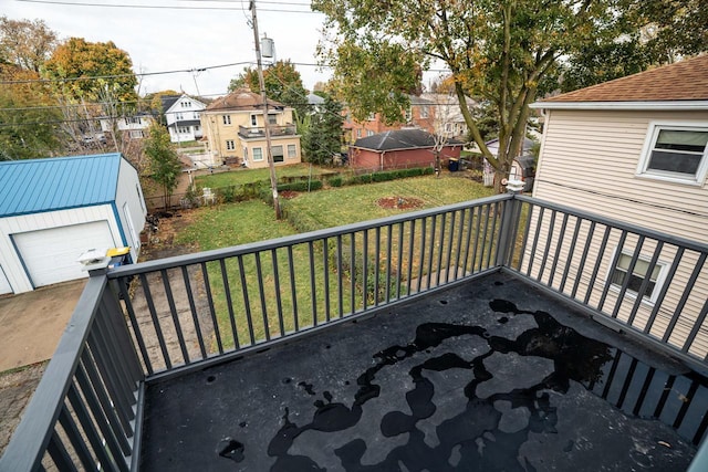 wooden deck featuring an outbuilding, a garage, and a lawn