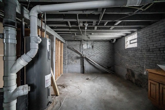 basement with electric water heater and brick wall