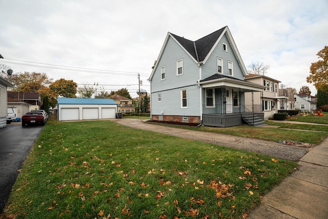 view of home's exterior featuring a lawn, a porch, a garage, and an outdoor structure