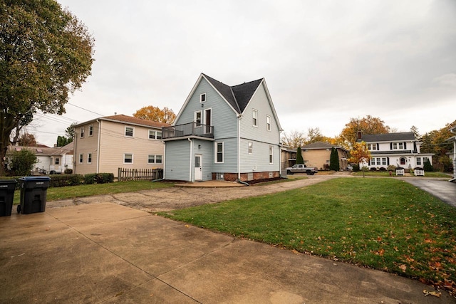 view of side of property featuring a lawn and a balcony