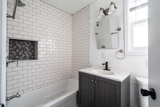 full bathroom featuring tiled shower / bath, vanity, and toilet