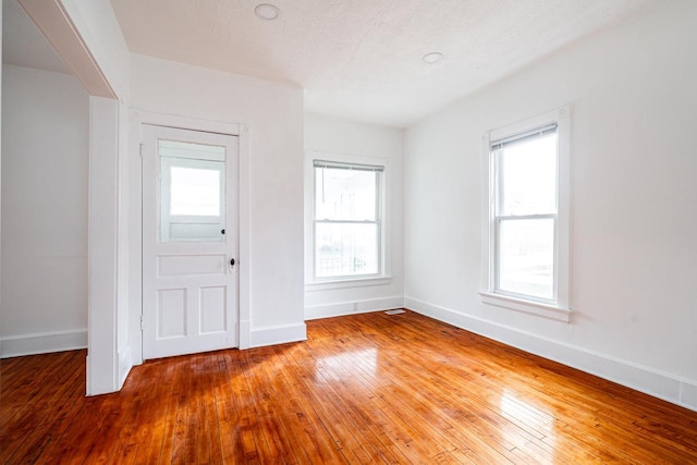 foyer with a healthy amount of sunlight, a textured ceiling, and hardwood / wood-style flooring