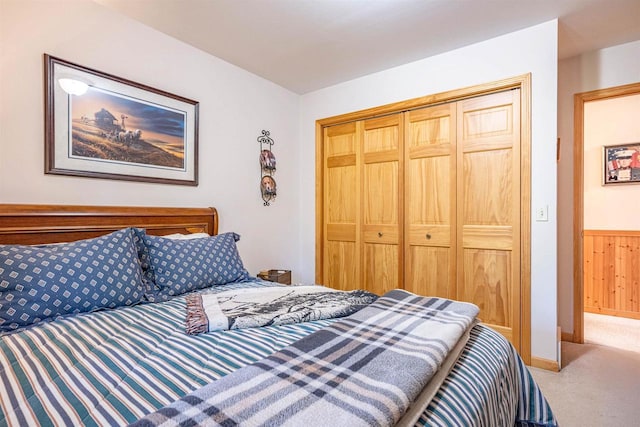 bedroom featuring carpet flooring, wooden walls, and a closet