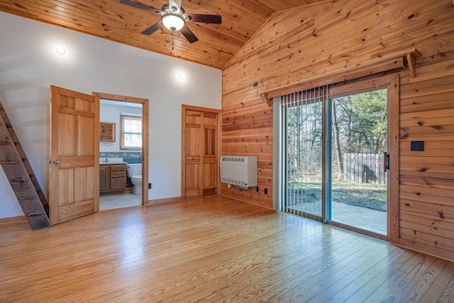 unfurnished living room featuring plenty of natural light, wood walls, wood ceiling, and high vaulted ceiling