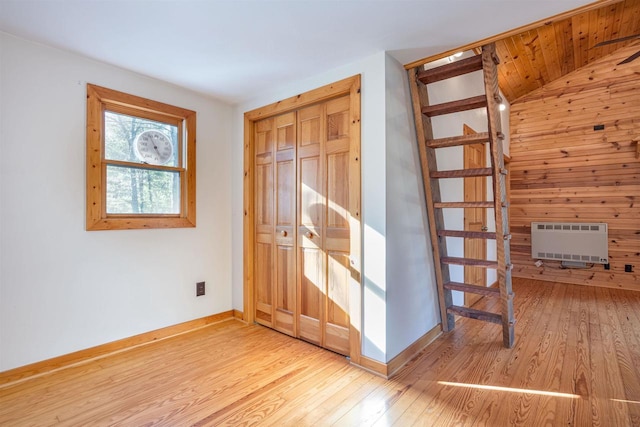 foyer featuring heating unit, light hardwood / wood-style flooring, and vaulted ceiling