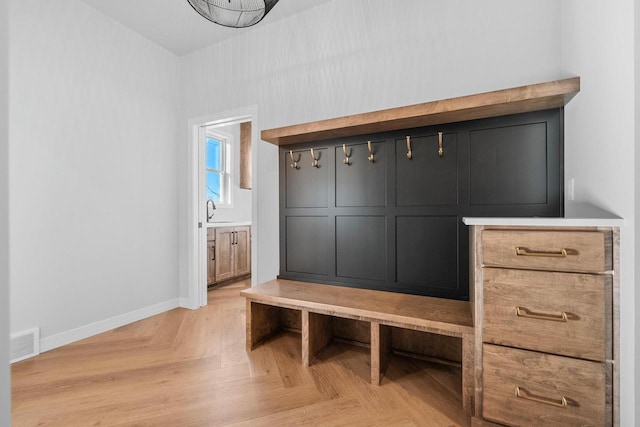 mudroom featuring sink and light parquet flooring